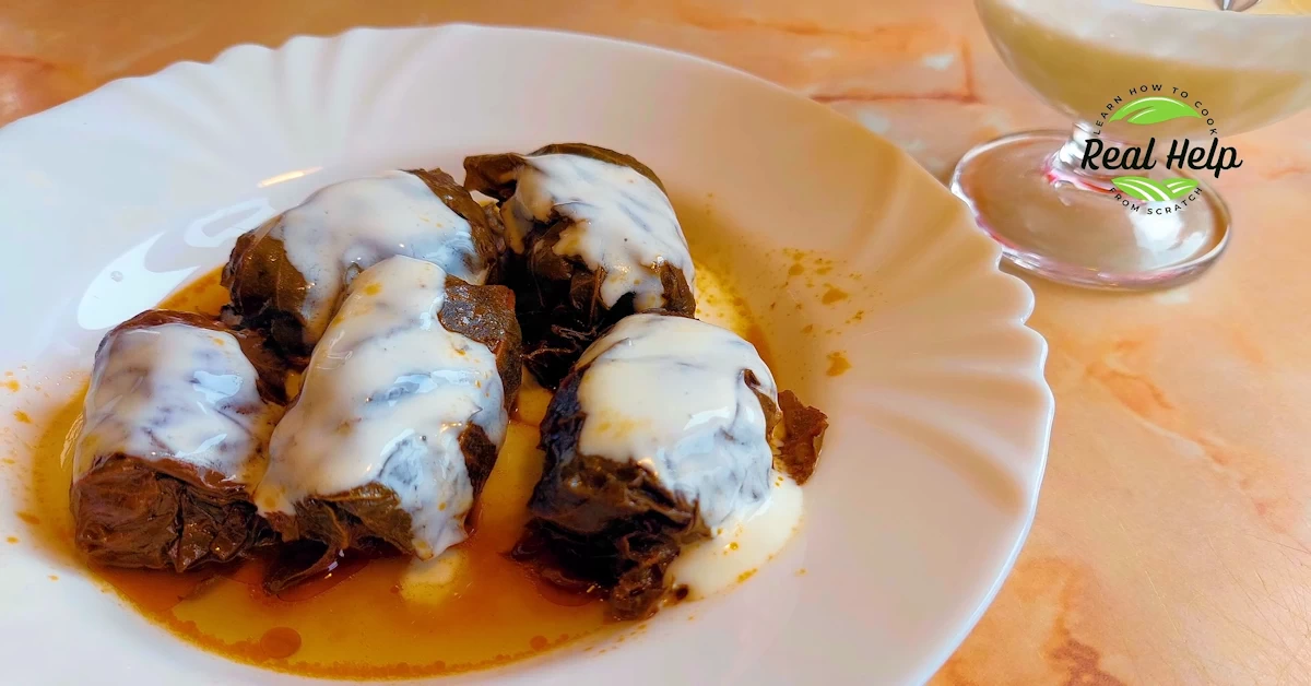 Traditional Romanian Sarmale Wrapped in Grape Leaves, Served with Sour Cream.